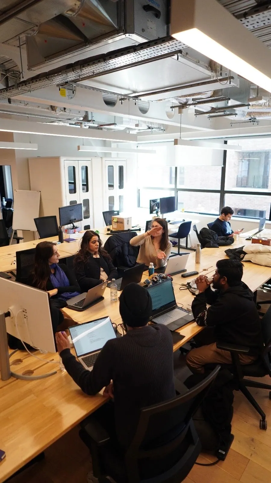 Participants at long desks in the hacker space