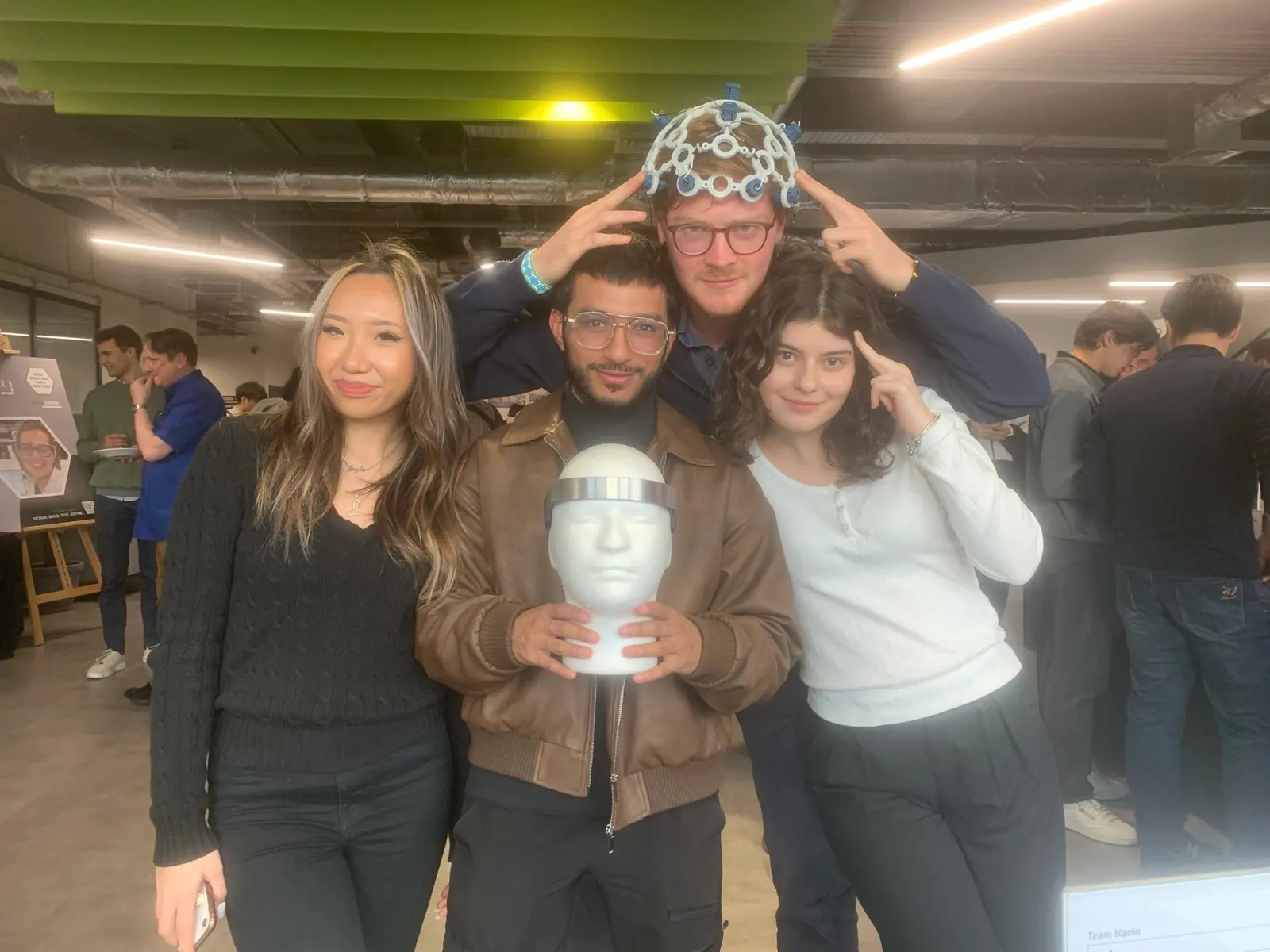 The HALO team at the Hackstarter Grand Final holding an EEG headset and a mannequin head