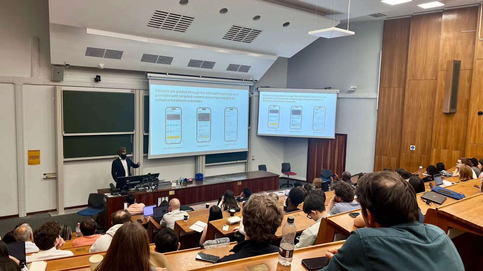 Wide view of a full lecture theatre during a talk