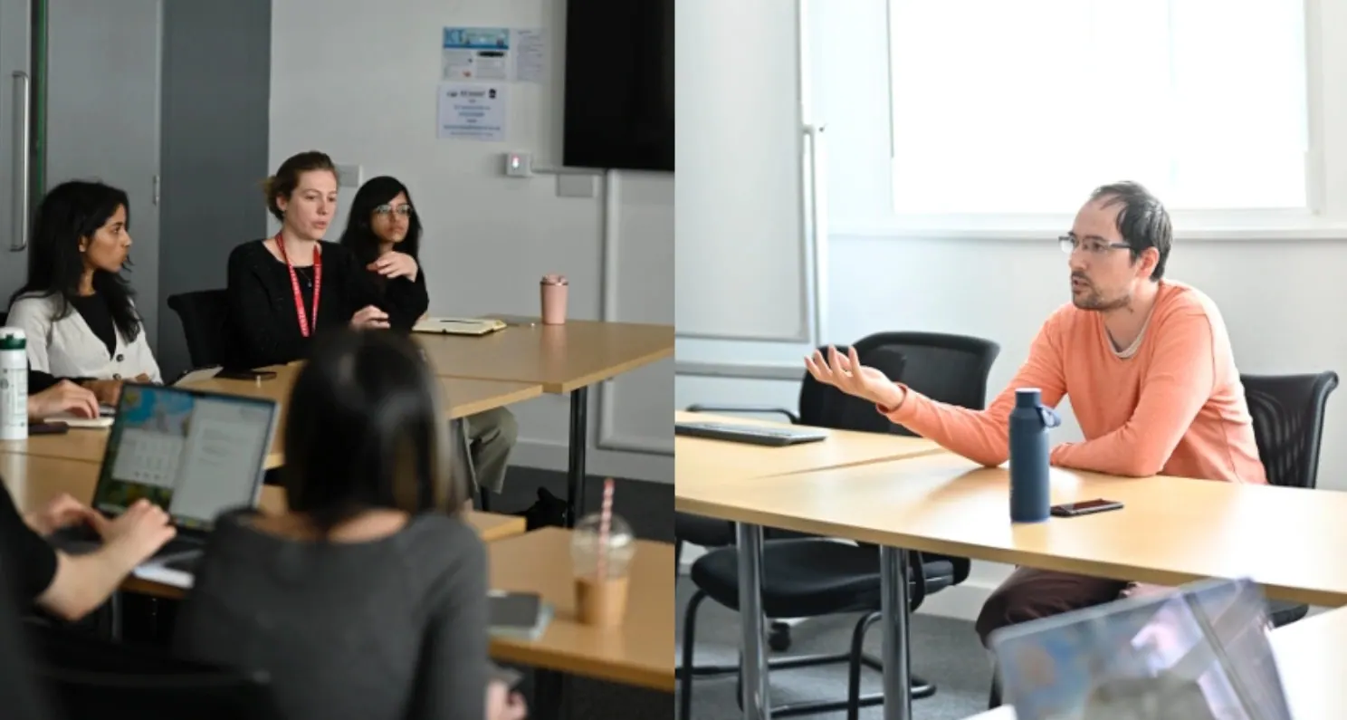 Students in conversation with a guest around a meeting table